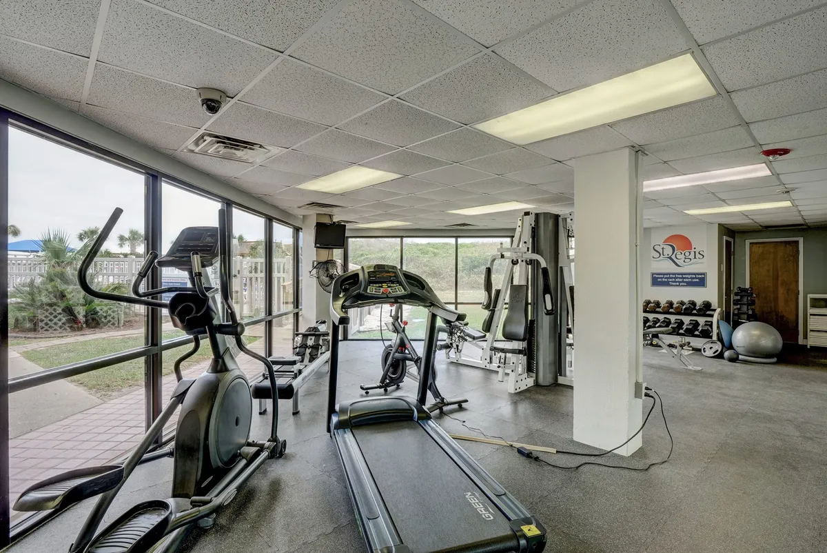 A bright and motivating fitness center with treadmills, an exercise bike, weight machines, and large windows letting in natural light. The layout is open, modern, and welcoming for personal workouts or group fitness.